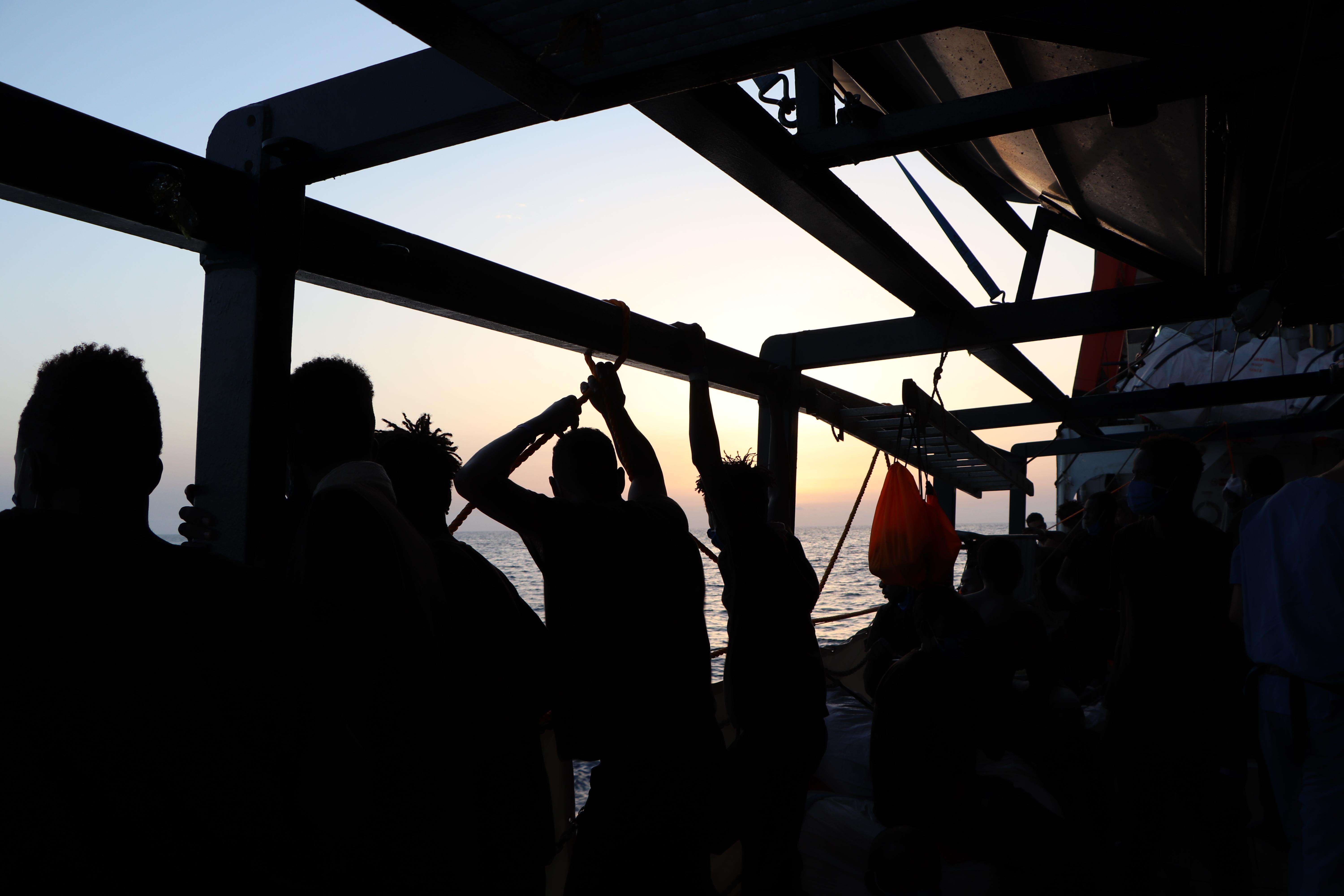 Migrants on a ship in the shadow