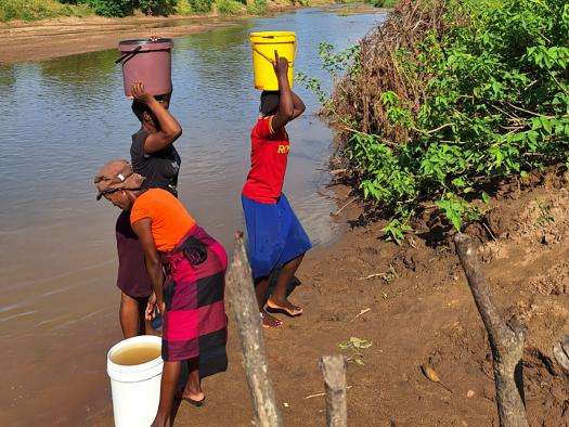 Women fetch wate from a river in Zimbabwe.