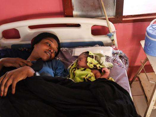 A woman with her baby in a hospital bed in South Darfur, Sudan.