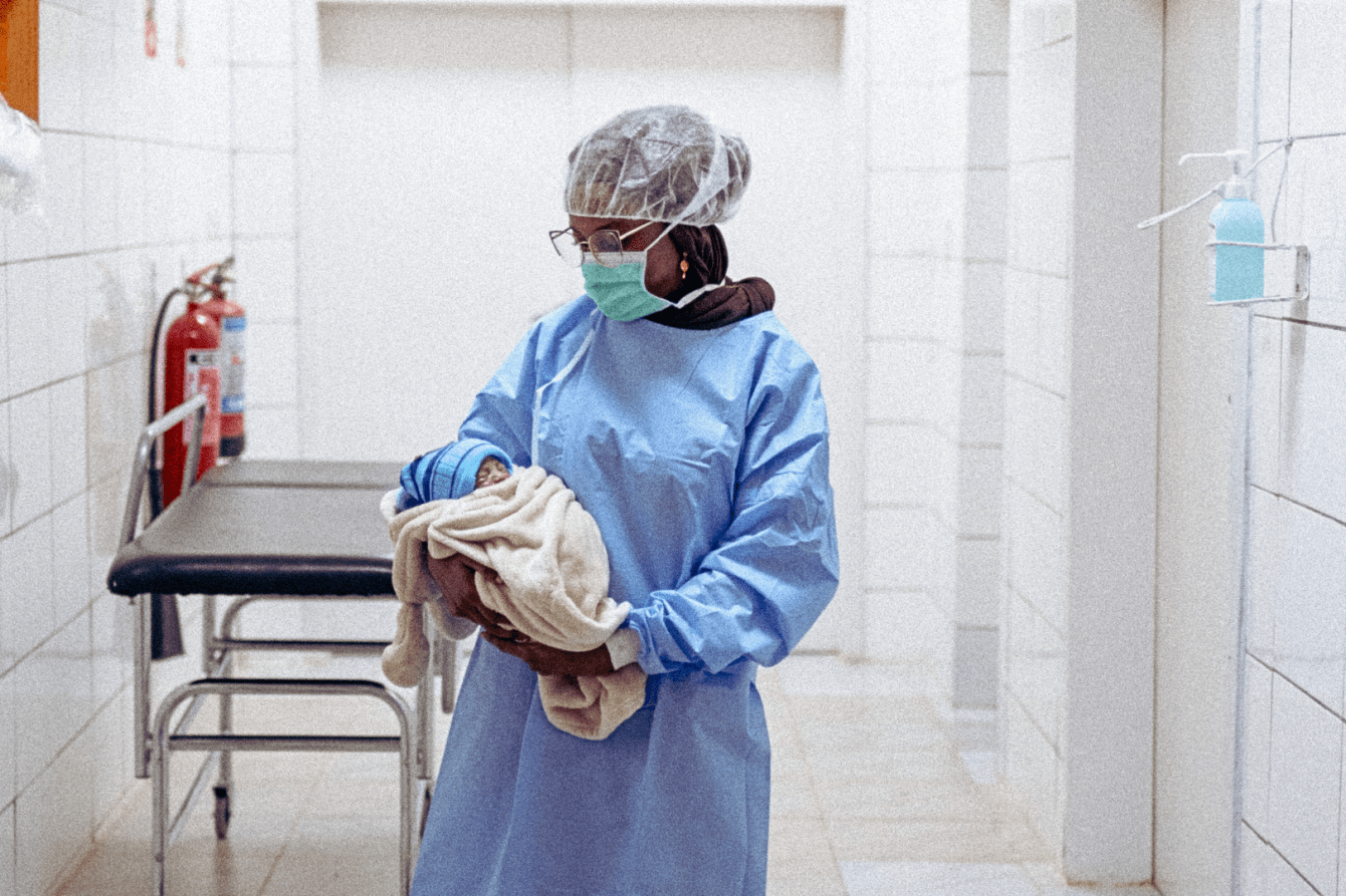 Dr. Amina Egujja holds a newborn after a cesarean section in the operating theater for obstetrics at Nilefa Keji Hospital