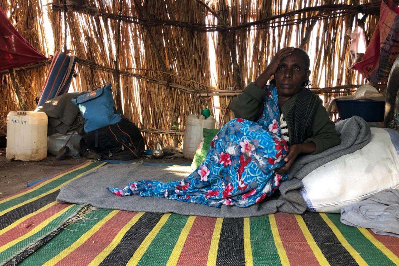 Woman laying on floor inside shelter.