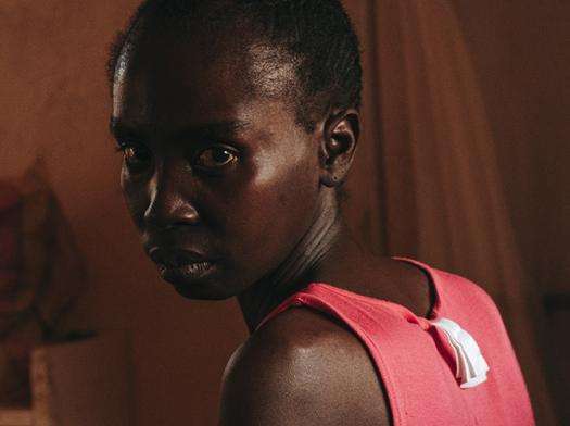 A woman with short hair turns to face the camera after receiving medical care from MSF in Central African Republic.