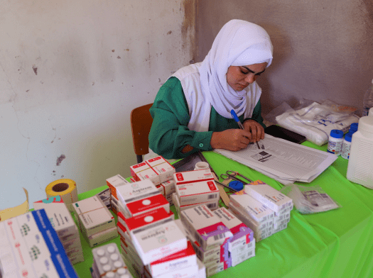 Hala Hussein, MSF dispenser, receives patients after their consultations to give them their prescribed medications.