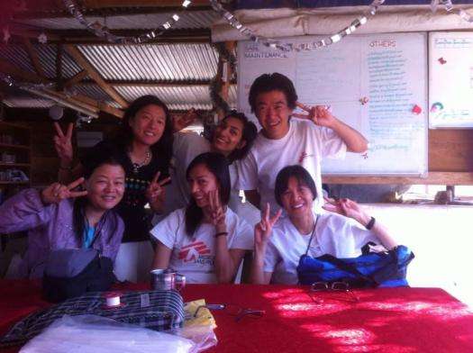 MSF staff sit at a table smiling and making in front of a white markerboard