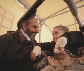 A man smiles at an injured child in Gaza.